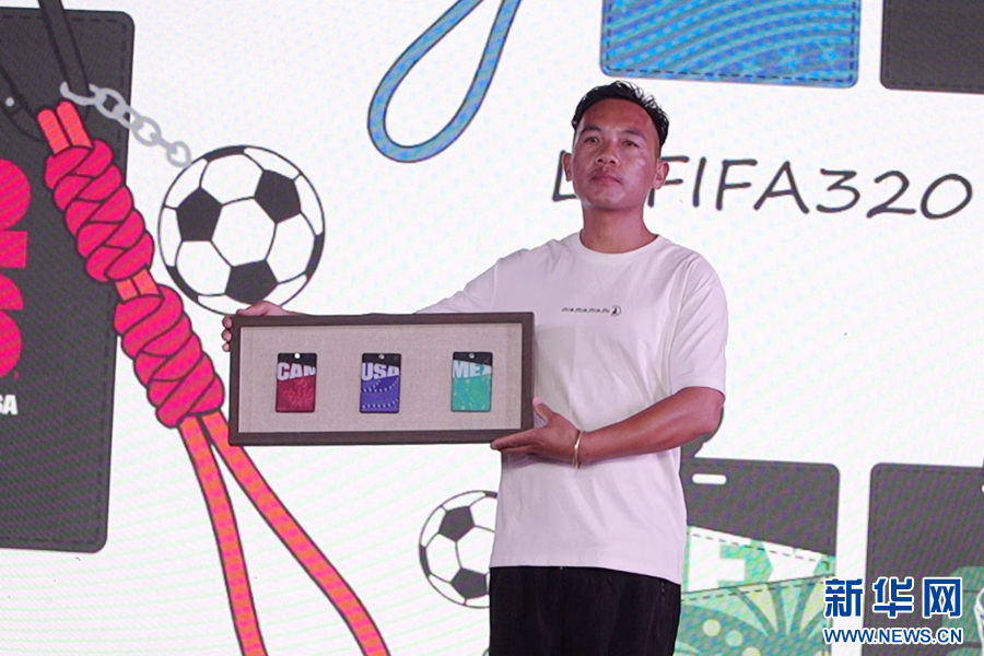 工作人员展示“非遗遇见世界杯”彝绣卡套(资料图)。新华网发(楚雄州委宣传部 供图)